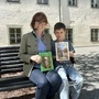 Eine Frau sitzt mit ihrem Enkel auf einer Parkbank