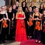 Musikerinnen stehen mit ihren Instrumenten in einem Dom