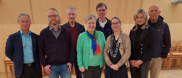 Acht Personen stehen nebeneinander