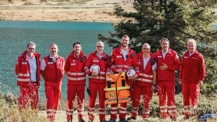 Männer stehen in ihrer Ausrüstung vor einem See