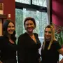 Drei Frauen stehen in einem Friseursalon