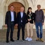 Vier Personen stehen vor dem Eingang einer Kirche