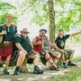 Männer in Tracht sitzen in einem Wald