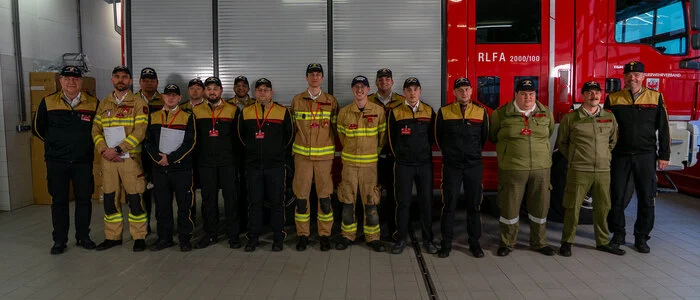 Feuerwehrkameraden vor einem Feuerwehrauto