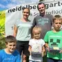Eine Familie steht in einem Heidelbeerfeld
