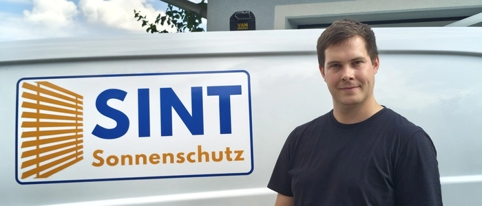 Ein Mann vor seinem Firmenauto