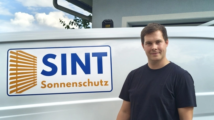 Ein Mann vor seinem Firmenauto