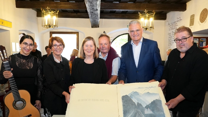 Sechs Personen halten ein großes Buch