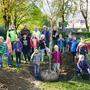 Kinder und Stadtgärtner beim Pflanzen eines Patenschaftsbaumes