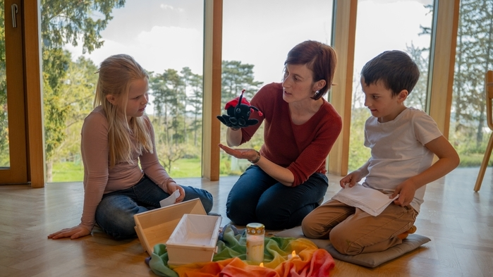 Kinder unterhalten sich mit einer Erwachsenen
