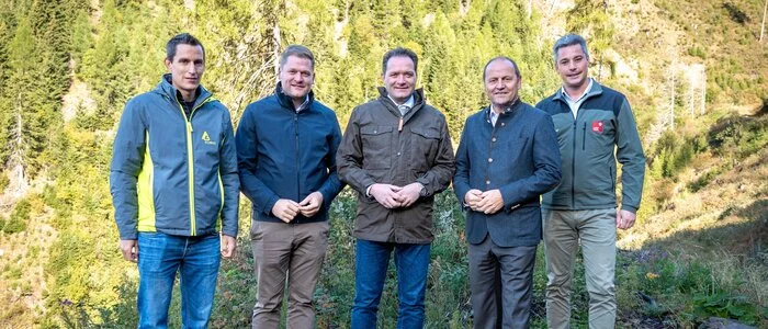 Fünf Männer stehen in einem Wald