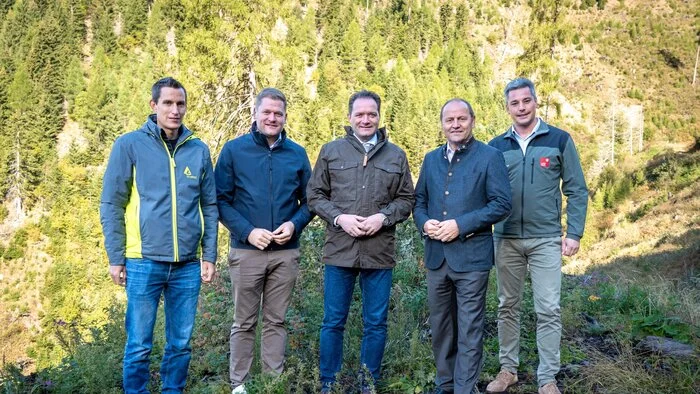 Fünf Männer stehen in einem Wald