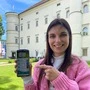 Eine junge Frau hält ein Handy in die Höhe