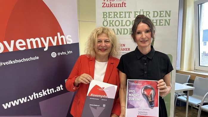 Zwei Frauen stehen vor großen Plakaten