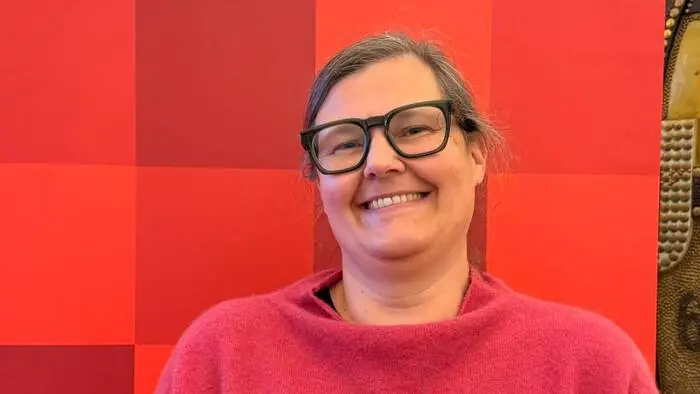 Eine Frau steht vor einem Plakat