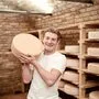 Ein Mann steht vor einem Regal voller Käse