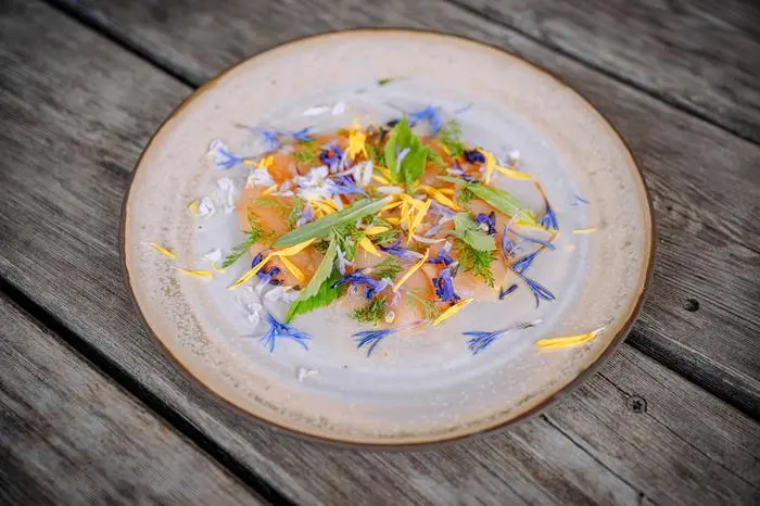 Die Forelle wurde mit bunten Wiesenkräutern und Blumen dekoriert