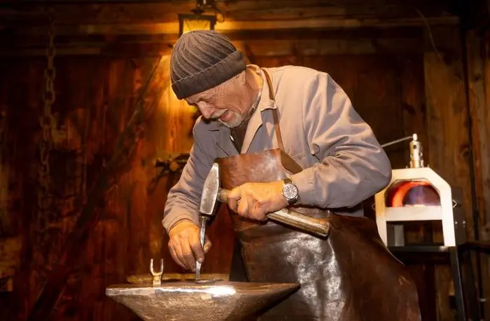 Rudl Duregger stellt in seiner mobilen Schmiede Glücksbringer her