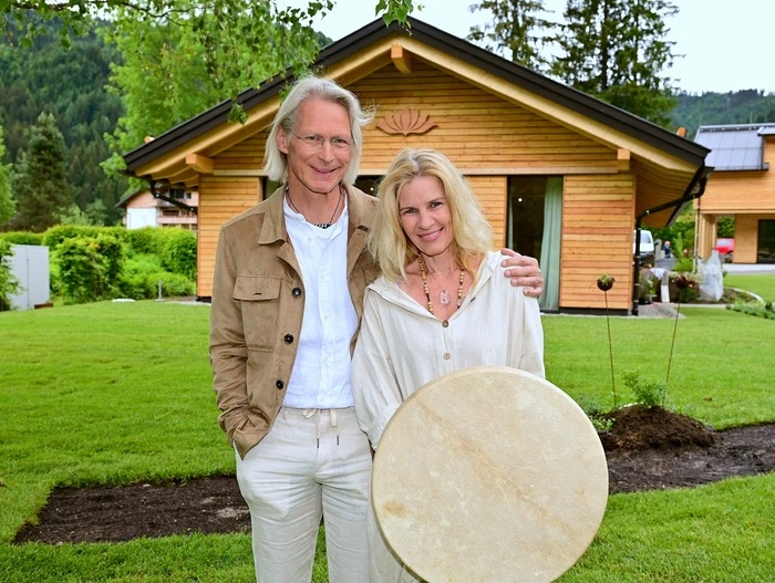 Zwei Personen vor einem Holzhaus