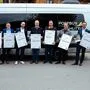 Acht Personen stehen vor einem Fahrzeug | Landesrat Sebastian Schuschnig (zweiter von rechts) bei der Präsentation des Postbus Shuttle Oberes Drautal