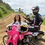 Eine junge Frau mit einem Motorradfahrer auf einer Rennstrecke