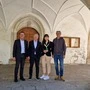 Vier Personen stehen vor dem Eingang einer Kirche