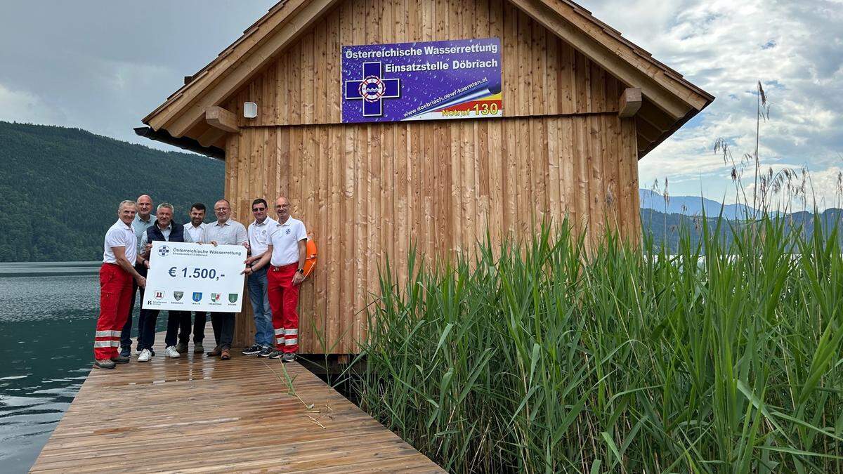 Bürgermeister und Mitglieder der Wasserrettung bei der Spendenübergabe in Döbriach