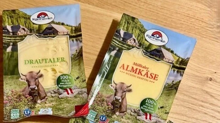Vier Packungen Käse liegen auf einem Tisch