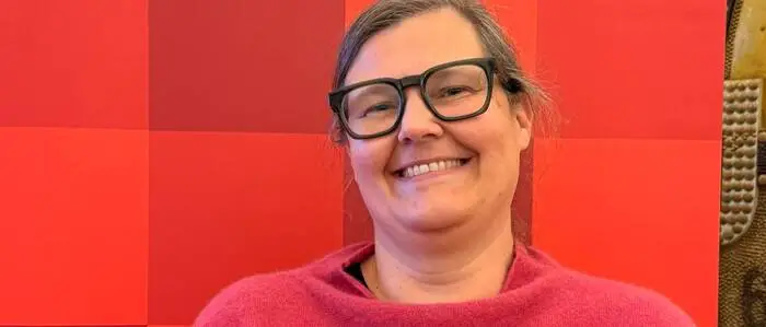Eine Frau steht vor einem Plakat