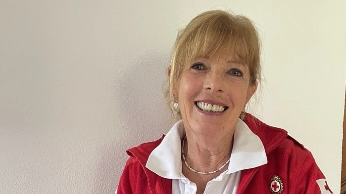 Eine Frau mit einer Box voller Lebensmitteln in der Hand
