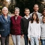 Sieben Familienmitglieder stehen in einem Wald