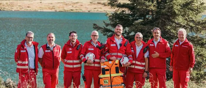 Männer stehen in ihrer Ausrüstung vor einem See