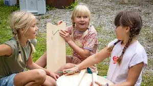 Drei Kinder mit Holzstücken