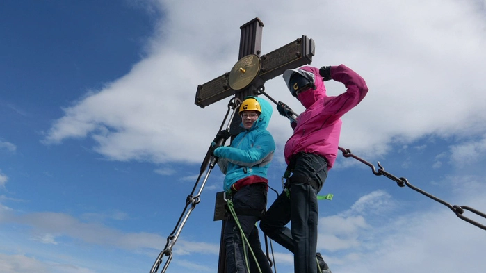 Zwei Mädchen stehen auf einem Berggipfel
