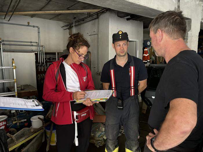 Caritas-Mitarbeiterin Nina Pokorny füllt mit Alexander Lax,  Kommandantstellvertreter der Freiwilligen Feuerwehr Kremsbrücke, einen Hilfsantrag für einen Betroffenen aus        