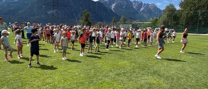 Eine Gruppe Schüler tanzt auf einer Wiese