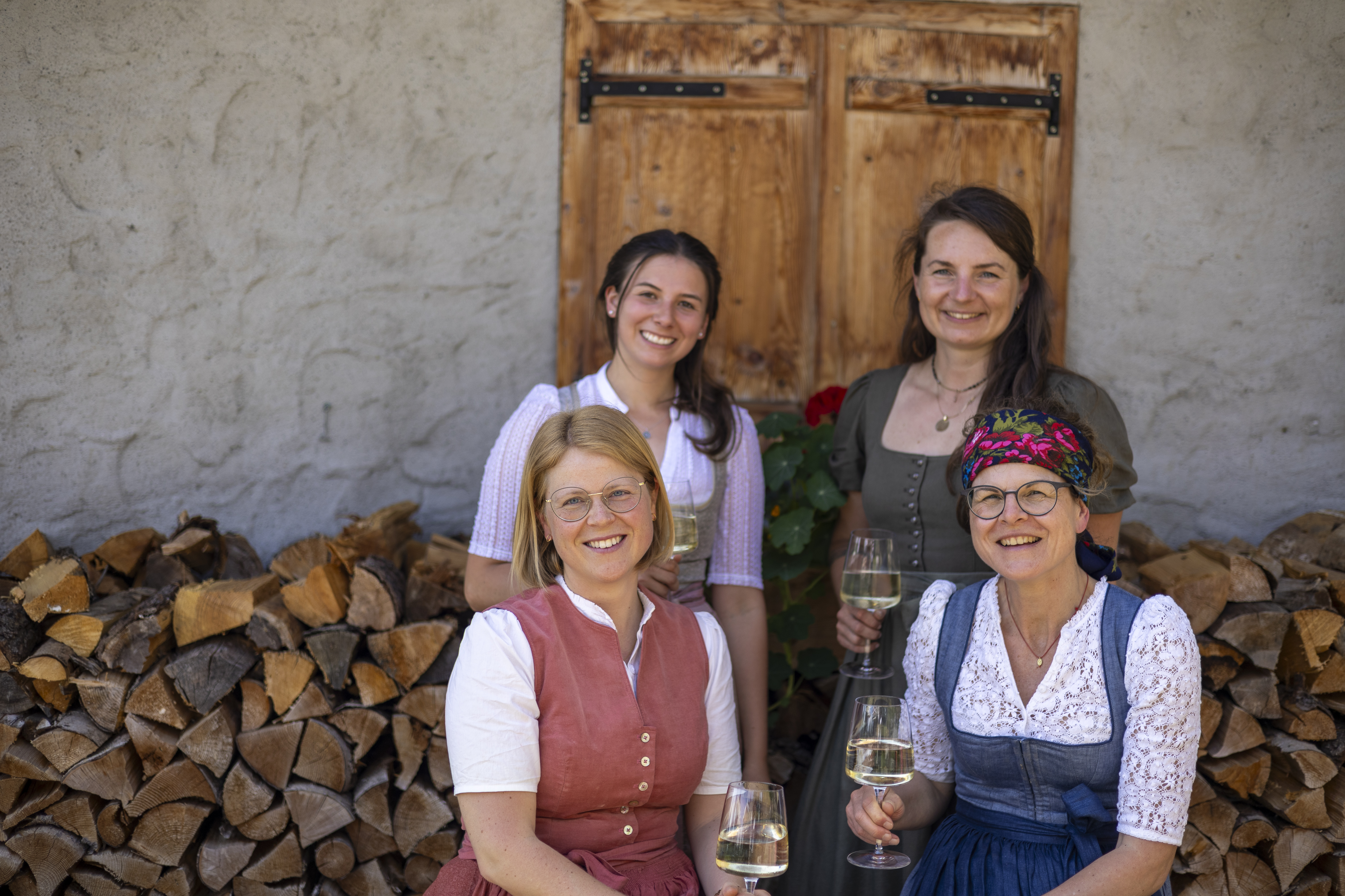 Vier Frauen sitzen vor einer Hütte