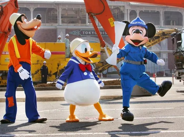 ** BYLINE TITLE SHOULD BE STF INSTEAD OF ORIGINALLY STATED **Mickey Mouse, right, in construction worker's outfit, jumps as he is joined by Donald Duck, center, and Goofy, during a ceremony to start Tokyo Disneyland Hotel construction at the site in Urayasu near Tokyo Tuesday, Feb. 14, 2006. The hotel, the third one run by The Walt Disney Co.'s Japanese amusement park operator Oriental Land Co., will open in 2008 in front of the Tokyo Disneyland Station. (AP Photo/Itsuo Inouye) 