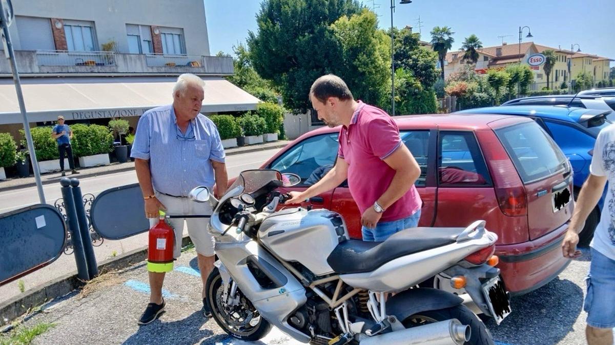 Der Bürgermeister (links) löschte die Flammen am Motorrad in San Daniele