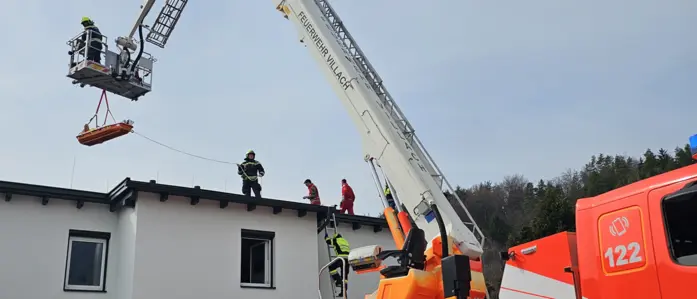 Mittels Korbtrage und Hubrettungsgerät wurde der Patient vom Hausdach gehoben.
