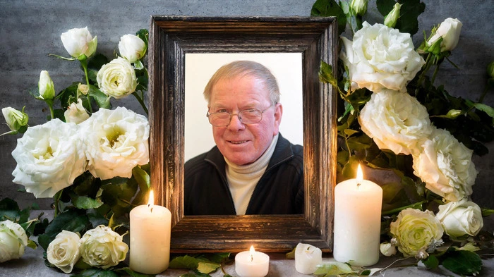 Vikar Johann Fercher auf einem Portraitbild, umgeben von Kerzen und weißen Blumen.
