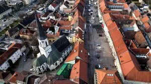 Eine Innenstadt von einer Drohne aufgenommen. Zu sehen sind ein Hauptplatz und eine Kirche.