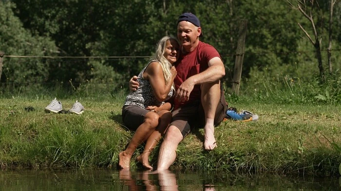 Zwei Menschen sitzen an einem Teich
