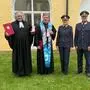 Männer und Frauen in Polizeiuniformen und Priestergewändern