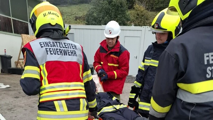 Feuerwehrmänner tragen eine Trage mit einer Person