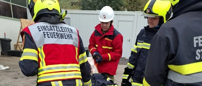Feuerwehrmänner tragen eine Trage mit einer Person