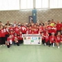 Eine Schulklasse jubelt und hält einen Pokal in die Luft 