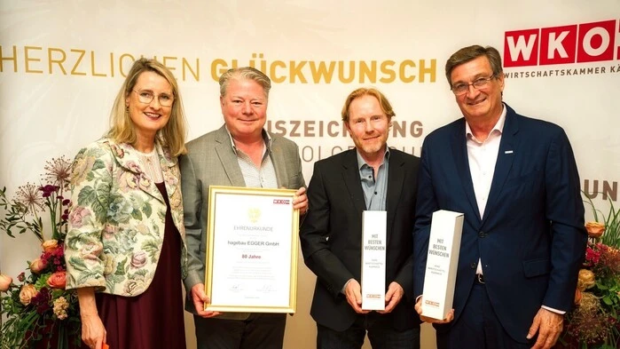 Vier Menschen stehen in einer Reihe und schauen in die Kamera 