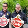 Zwei Menschen mit einem Schild in der Hand. Darauf ist „Havana Club“ zu lesen.