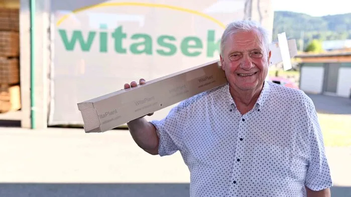 Ein Mann mit einer Kunststoffbaumschutzhülle auf dem Arm